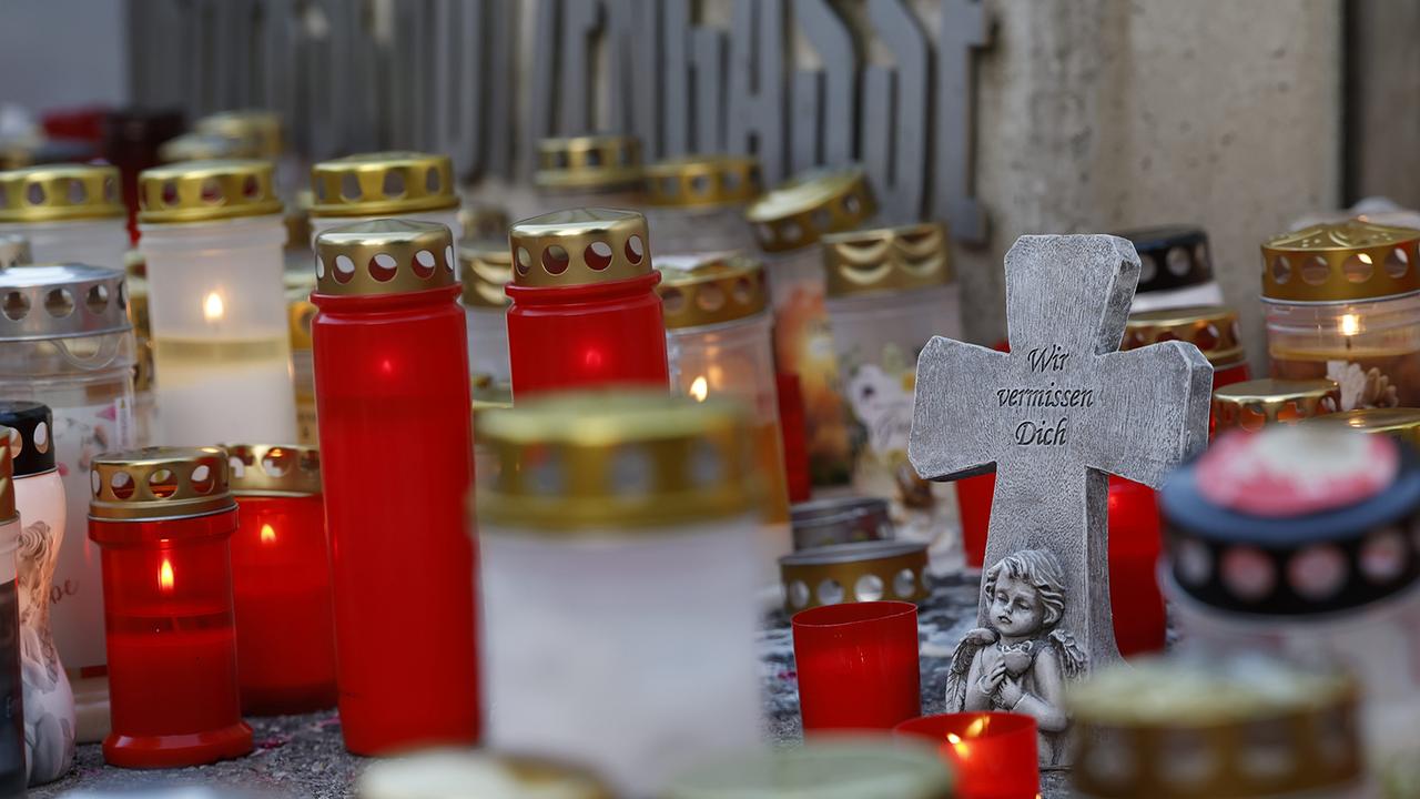 © APA/ERWIN SCHERIAU Ein Kreuz mit der Aufschrift "Wir vermissen dich" und Kerzen vor der Schule am Donnerstag, 12. Juni 2025, anl. einer Attacke mit zehn Todesopfern in einer Schule in Graz