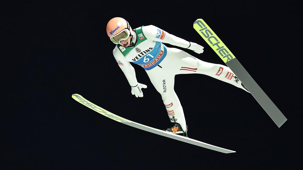 Jan Hörl beim Skispringen auf der Großschanze in Garmisch-Partenkirchen bei Dunkelheit in der Luft.