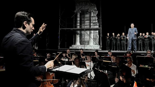 © ORF/Studio Amati Bacciardi/Silvano Bacciardi Ein Dirigent Iván López-Reynoso leitet das Orchestra del Teatro Comunale di Bologna, während Juan Diego Flórez und der Coro del Teatro Ventidio Basso vor einer antiken Säulenkulisse auftreten.