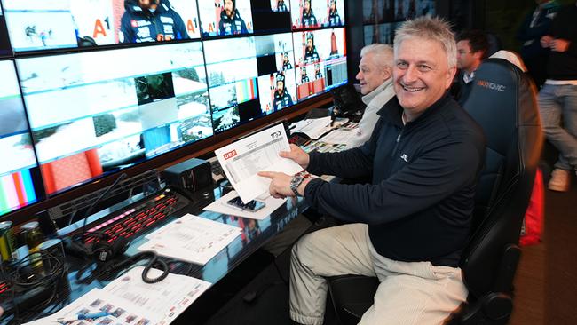 Chefregisseur Michael Kögler sitzt in der Regiezentrale mit zahlreichen Monitoren, im Hintergrund weitere Mitarbeitende einer Sport-Produktion