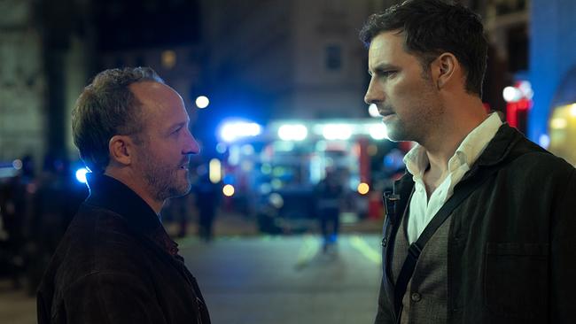 Kommissar Max Steiner und Inspektor Felix Burger stehen nachts einander gegenüber auf einer Straße, im Hintergrund sind Blaulichter und Einsatzfahrzeuge zu erkennen.