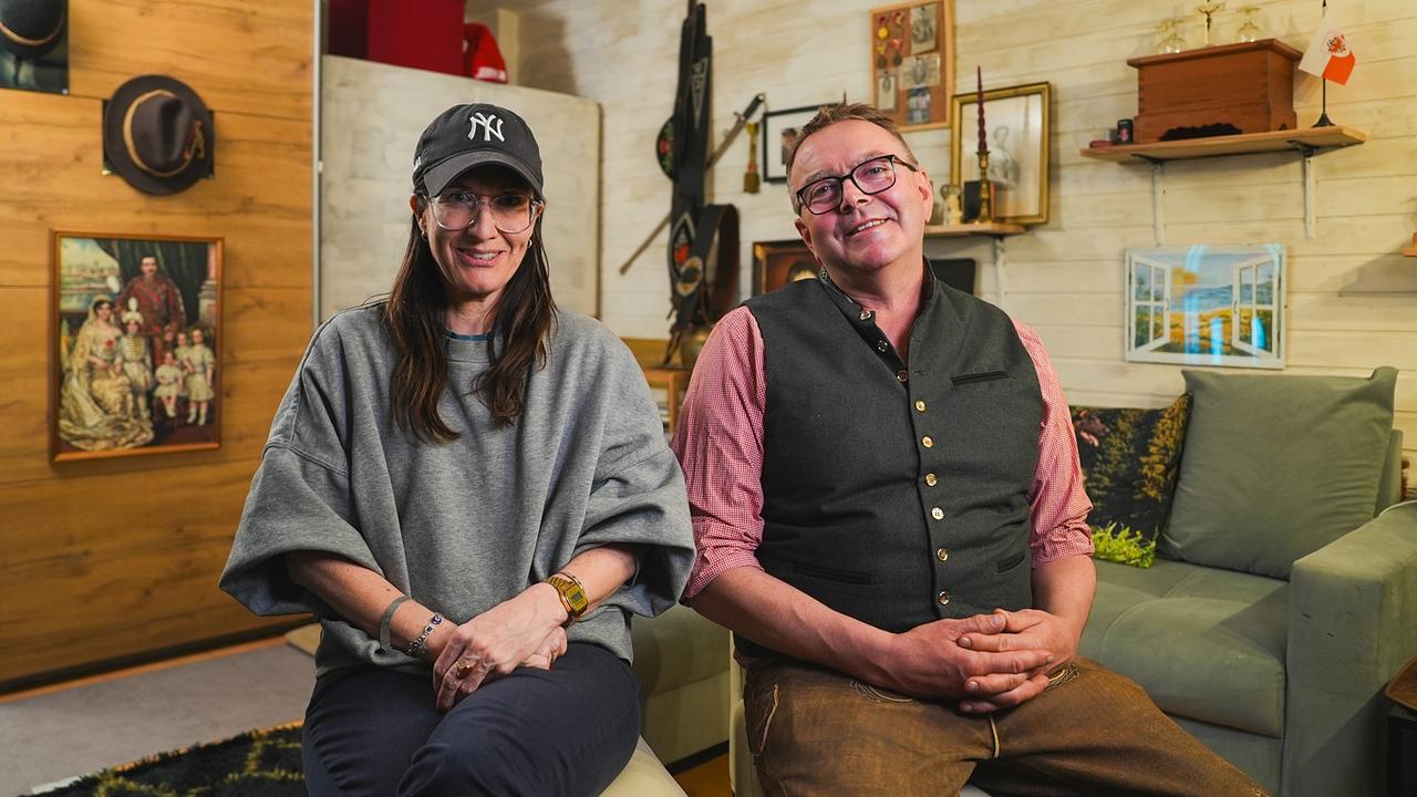 © ORF/Talk TV/Wout Kichler Nina Horowitz und Michl, 51, Bäckermeister aus Tirol, sitzen in einem gemütlich eingerichteten Wohnzimmer mit vielen Bildern und persönlichen Gegenständen an den Wänden.