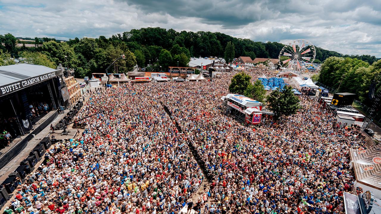 © ORF/WDB/Jakob Zeller Eine riesige Menschenmenge steht beim "Woodstock der Blasmusik" vor einer großen Bühne, im Hintergrund ist ein Riesenrad zu sehen.