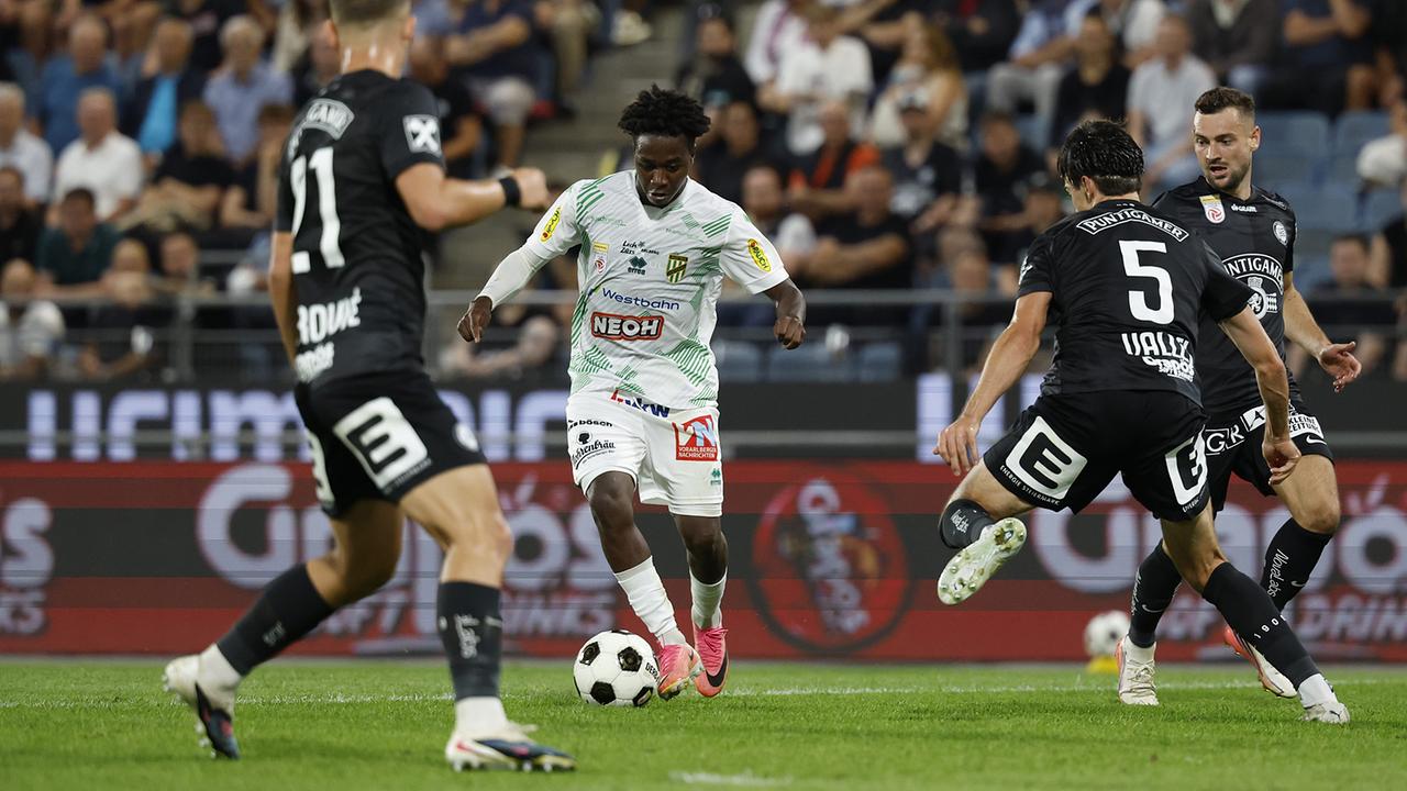 © APA/ERWIN SCHERIAU Fußballspieler Seydou Diarra von Austria Lustenau im weiß-grünen Dress dribbelt im Fußballspiel zwischen drei Gegenspielern Petar Petrovic, Albert Vallci und Jürgen Heil von Sturm Graz in schwarzen Dressen.