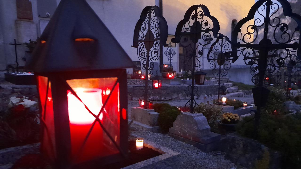 Brennende Grabkerze in einer Laterne auf einem Grab auf dem Friedhof Traunkirchen in Allerheiligenstimmung