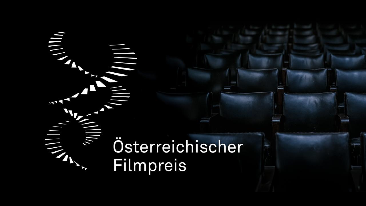 © ORF/Hans Leitner Das Bild zeigt das Logo zum Österreichischen Filmpreis vor einer dunklen, leeren Kinosaal‑Kulisse mit schwarzen Ledersesseln.