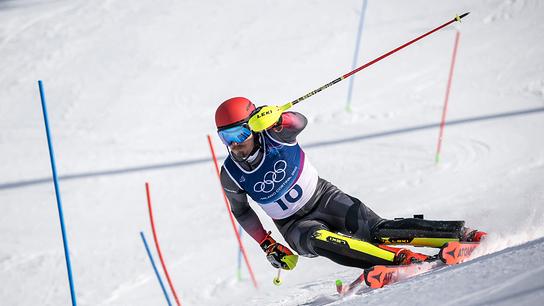 © APA/AFP/Fabrice COFFRINI Der Slalomfahrer Manuel Feller im Olympia-Rennanzug mit Startnummer 10 fährt in extremer Schräglage durch einen Stangenkurs beim Slalomlauf der alpinen Teamkombination der Herren bei den Olympischen Winterspielen Mailand-Cortina 2026 im Skizentrum Stilfser Joch in Bormio.