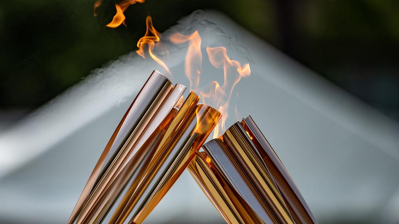 © APA/AFP/Philip FONG Fackelträger übertragen die olympische Flamme während des Fackelkusses bei der Lichtzeremonie im Hamacho Park im Stadtteil Nihonbashi von Tokio am 20. Juli 2021 Olympische Flamme