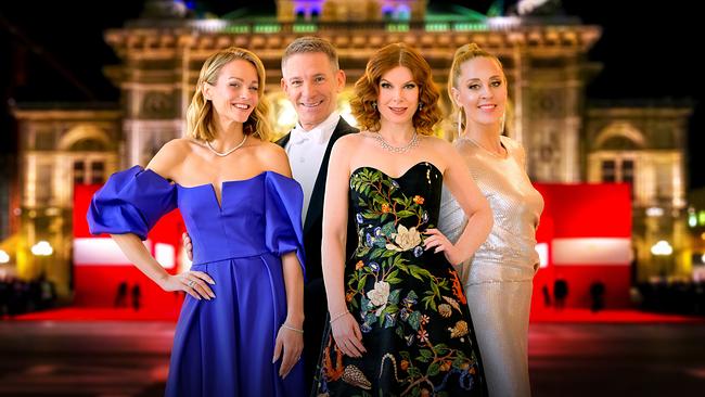 © ORF Mirjam Weichselbraun, Andi Knoll, Teresa Vogl und Lilian Klebow stehen abends in Ballkleidung auf einem roten Teppich vor der beleuchteten Wiener Staatsoper