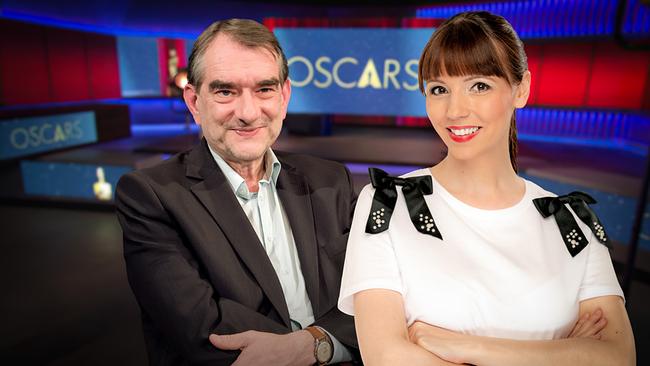 © ORF Alexander Horwath und Lilian Moschen stehen im TV-Studio vor einem Hintergrund mit dem Schriftzug „Oscars“.