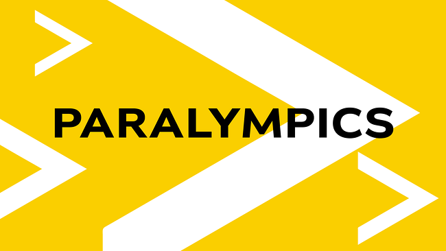 Eine gelbe Grafik mit weißen Pfeilformen zeigt mittig den schwarzen Schriftzug „PARALYMPICS“.