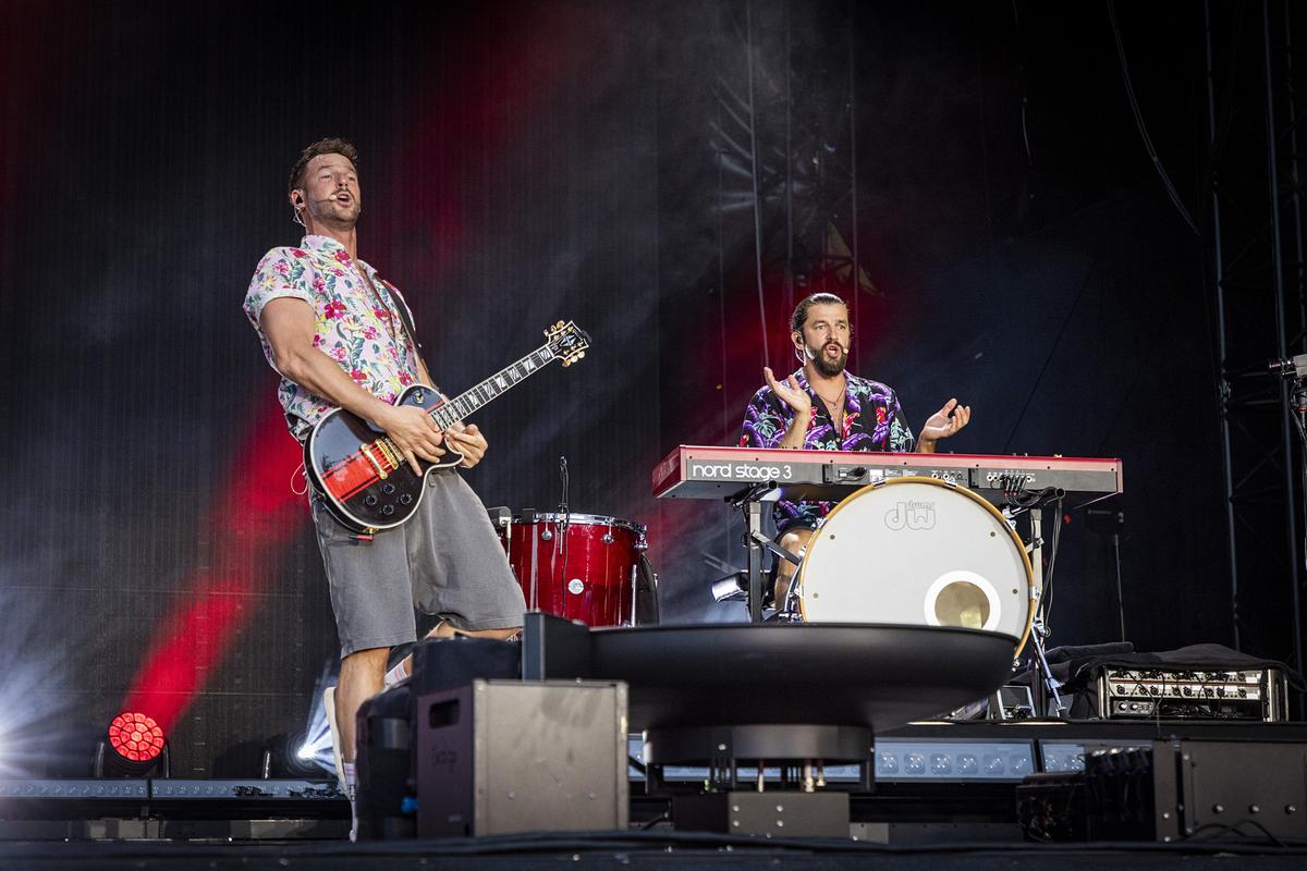 © ORF/ip|media/Peter Krivograd Pizzera & Jaus stehen in bunten Hemden auf der Bühne, einer an der Gitarre, der andere am Keyboard, bei ihrem Auftritt "Jetz' kummst ma auf de Tour!"