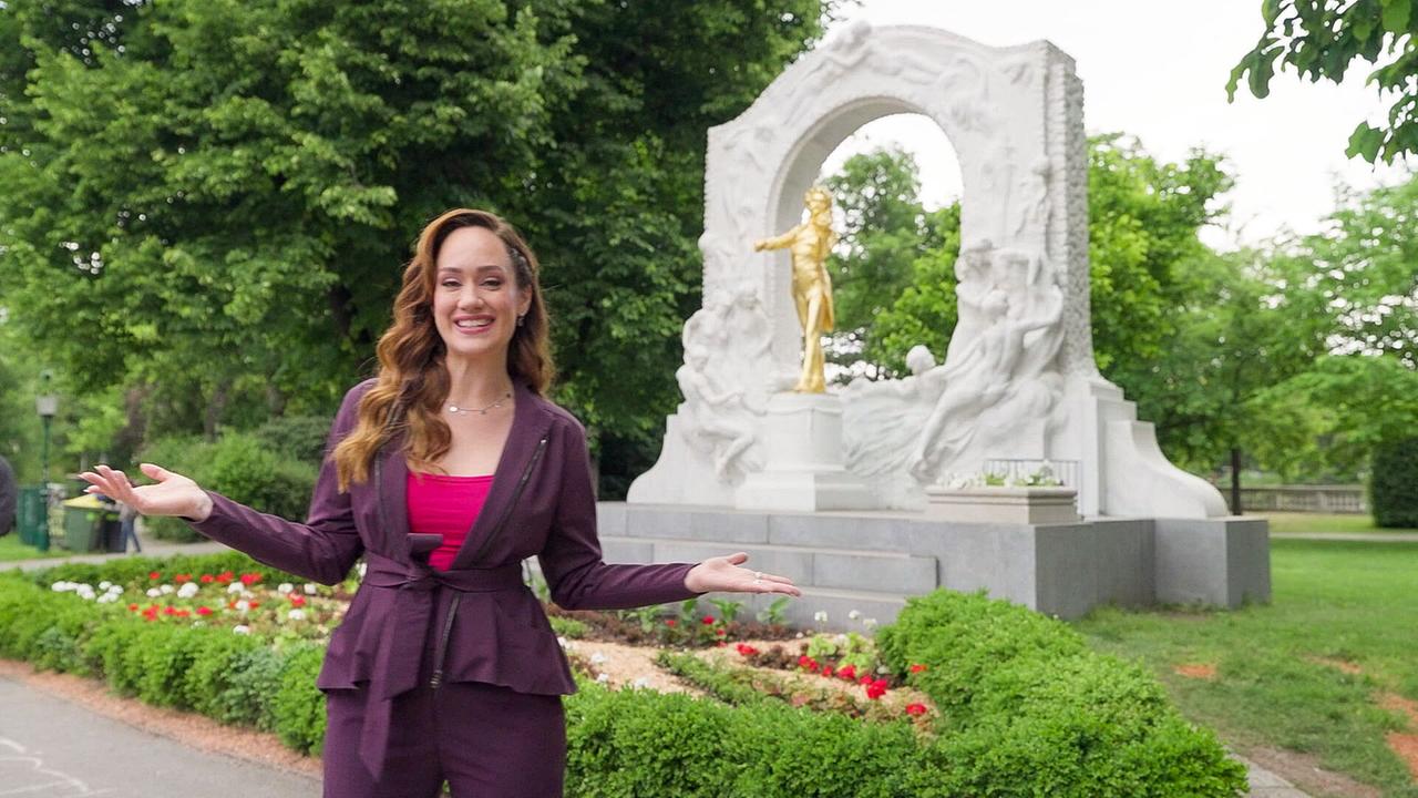 © ORF/TVfriends Sasa Schwarzjirg auf musikalischen Spuren in Wien steht vor dem berühmten goldenen Johann-Strauß-Denkmal im Wiener Stadtpark und gestikuliert in Richtung der Kamera.