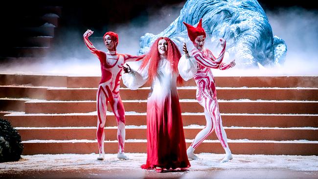 © ORF/Roman Zach-Kiesling Christina Nilsson im rot-weißen Kostüm steht mit zwei weiteren Darstellern vor einer schneebedeckten Elefantenkulisse auf der Bühne von "Ariadne auf Naxos".