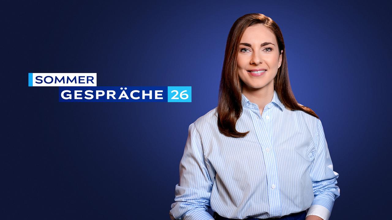 Simone Stribl steht vor einem dunkelblauen Studiohintergrund, neben ihr der Schriftzug „Sommergespräche 26“