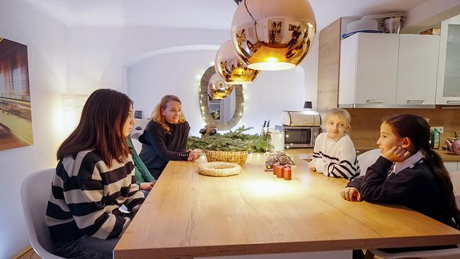 Unsere Weltenbummler Jasmin und Lisa sitzen an einem Tisch mit der evangelischen Pfarrerin Julia Schnizlein mit ihren zwei Töchtern und basteln zusammen einen Adventkranz.