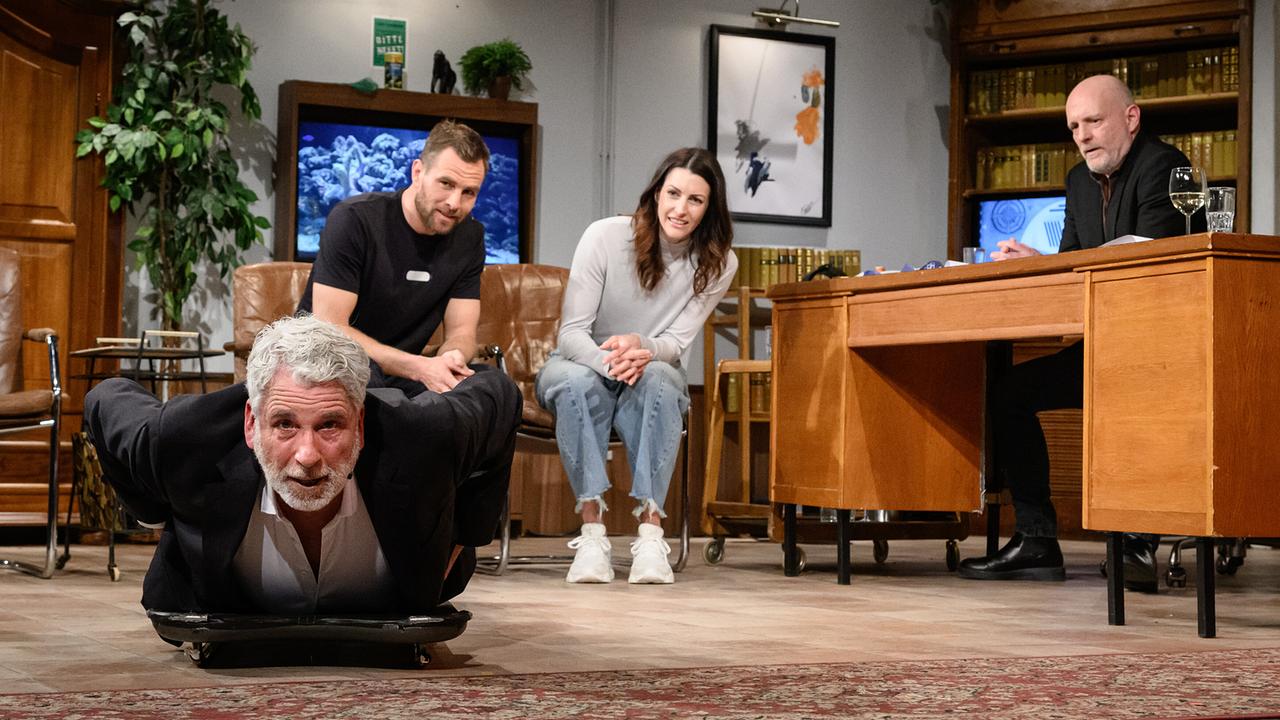 © ORF/Hans Leitner In einem Wohnzimmer-ähnlichen "Willkommen Österreich"-Studio liegt Dirk Stermann mit dem Bauch auf einem Bob, während Benjamin Karl, Janine Flock zuschauen und Christoph Grissemann hinter einem Schreibtisch sitzt.