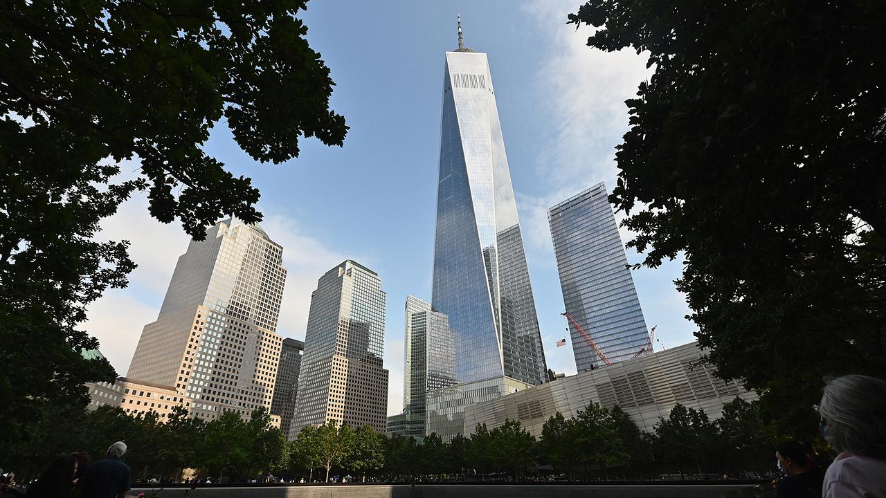 Mourners gather at the 9/11 Memorial & Museum, with Freedom Tower (C), in New York on September 11, 2020, as the US commemorates the 19th anniversary of the 9/11 attacks