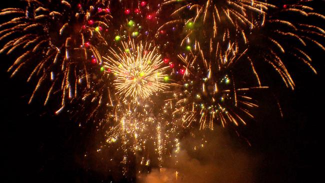 Mehrfarbige Feuerwerksfontänen erleuchten den Nachthimmel.