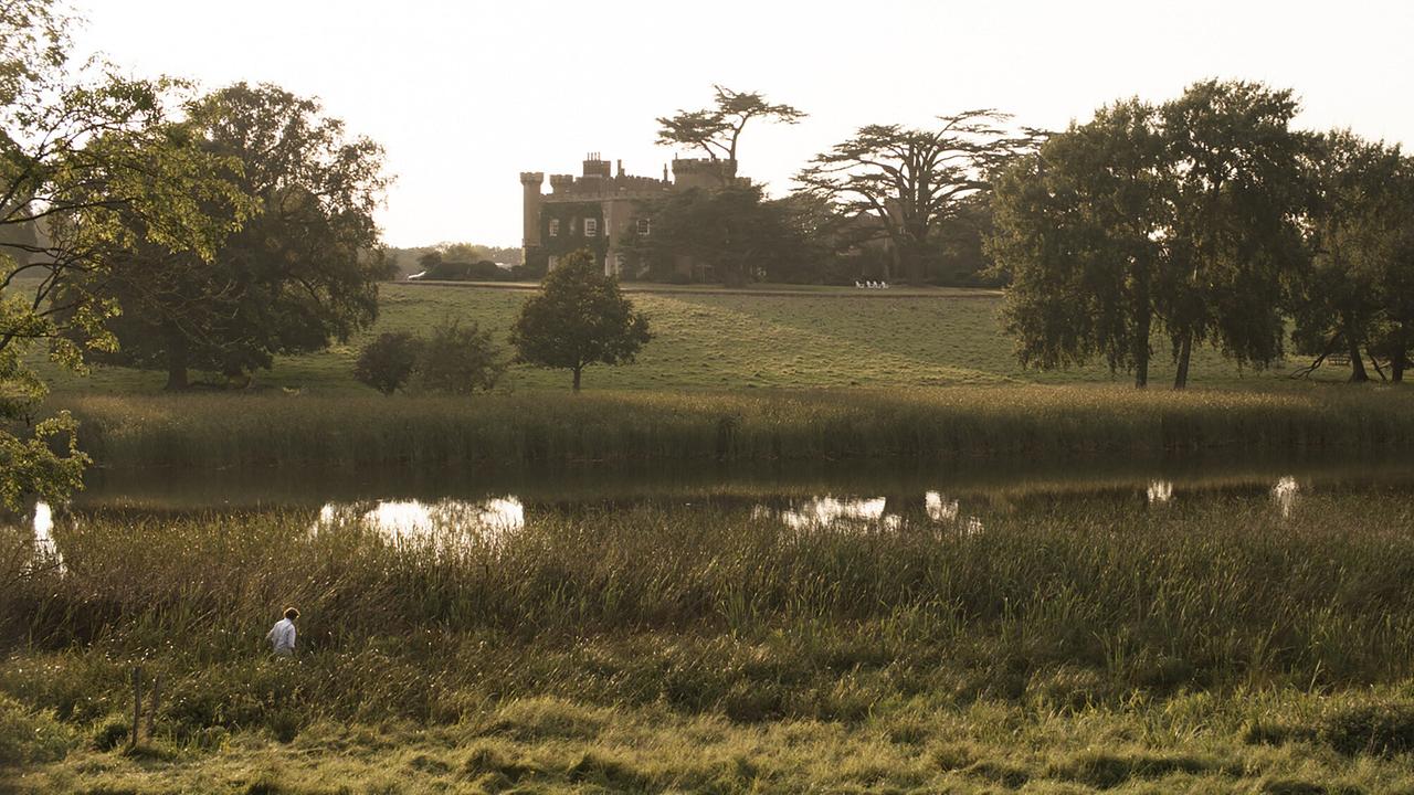 © ORF/Passion Pictures/HHMI Tangled Bank Studios Ein Schloss, davor ein Wassergraben. Eine Frau streift durch hohes Gras. Die Landschaft ist grün.