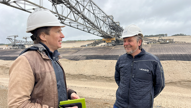 © ORF/Hafner Korrespondent Patrick A. Hafner und Bergmann Alexander Schmidt vor der größten beweglichen Arbeitsmaschine der Welt, der Förderbrücke F60. Sie soll demnächst gesprengt werden, da das Ende der Kohleförderung naht.